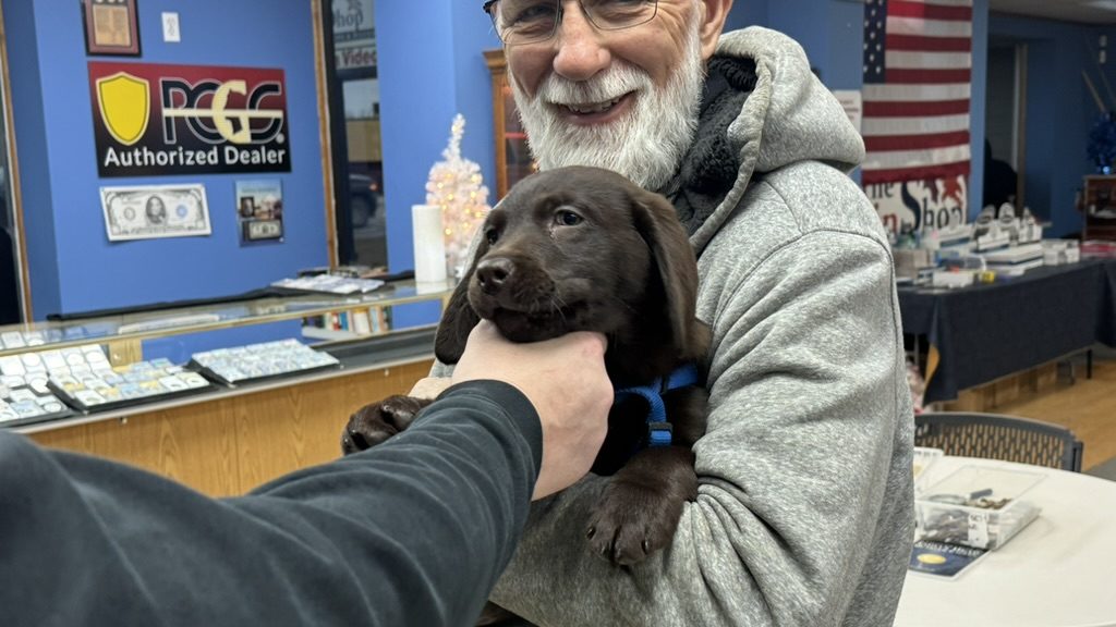 Happy customer with puppy visiting The Coin Shop in Brighton